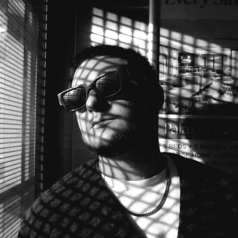Michael Rodriguez wearing sunglasses in patterned window light